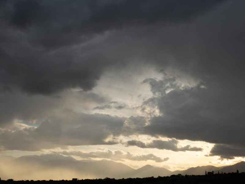 Mount Olympus emerging majestically from a sea of clouds under bright sunlight.