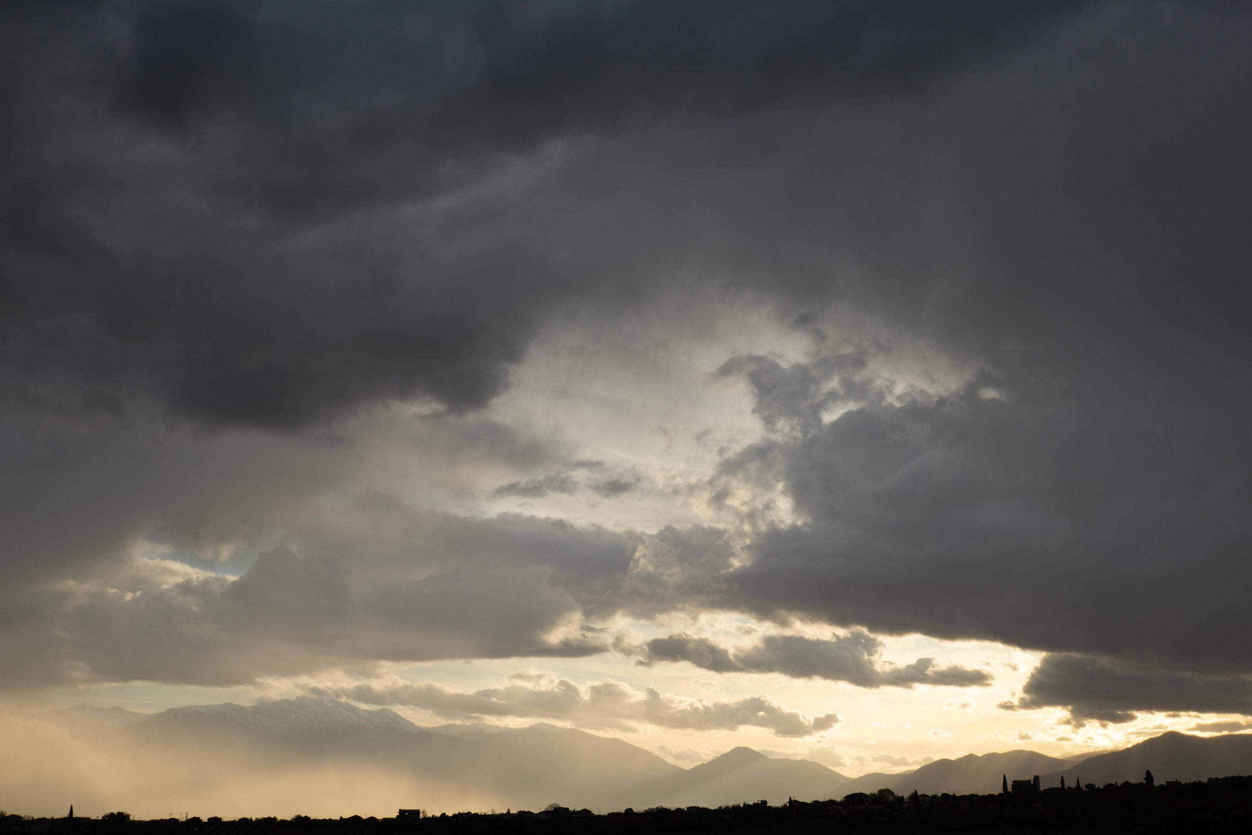 Mount Olympus emerging majestically from a sea of clouds under bright sunlight.