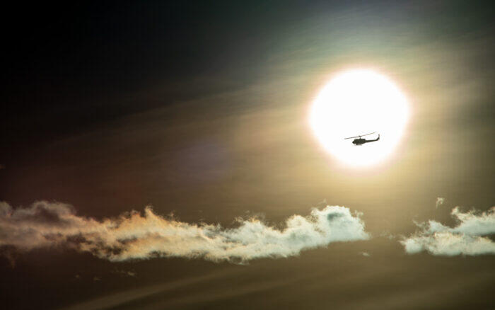 a helicopter in the morning in front of the sun!