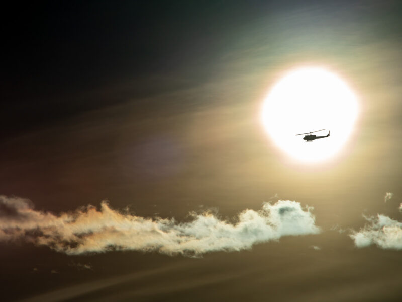 a helicopter in the morning in front of the sun!