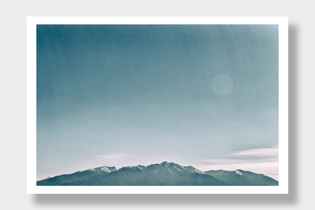 Panoramic shot of the majestic Mount Olympus in Greece. The image showcases the legendary mountain in dark gray and white tones, accentuating its sublime grandeur and rugged contours. A timeless portrayal of the enigmatic side of Olympus.