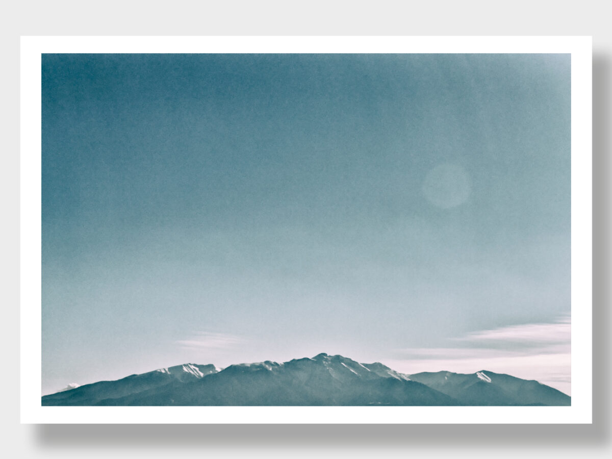 Panoramic shot of the majestic Mount Olympus in Greece. The image showcases the legendary mountain in dark gray and white tones, accentuating its sublime grandeur and rugged contours. A timeless portrayal of the enigmatic side of Olympus.