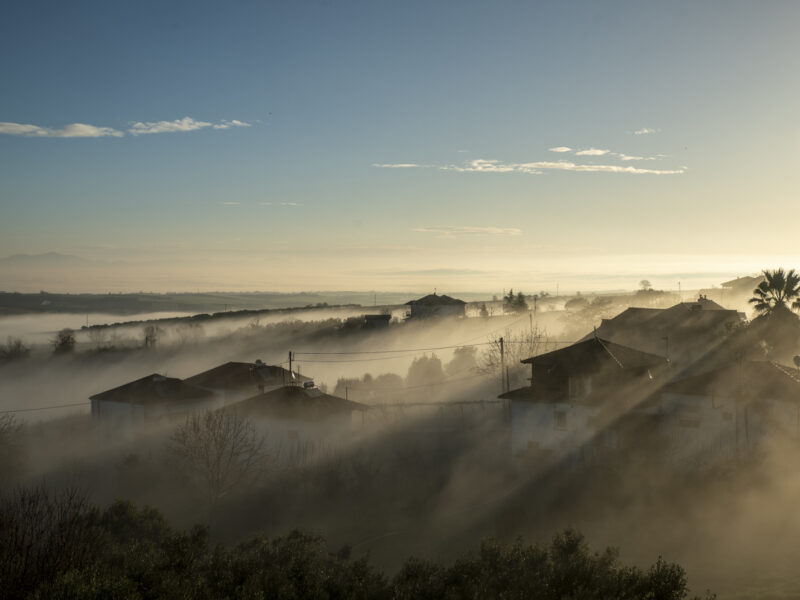 Expansive morning fog landscape over fields and village in Alonia Pieria