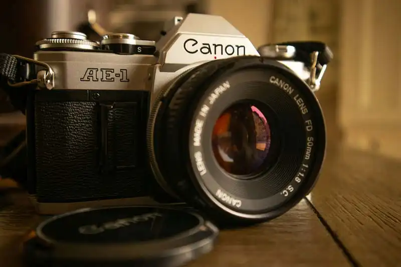 Vintage Canon AE‑1 film camera on wooden surface