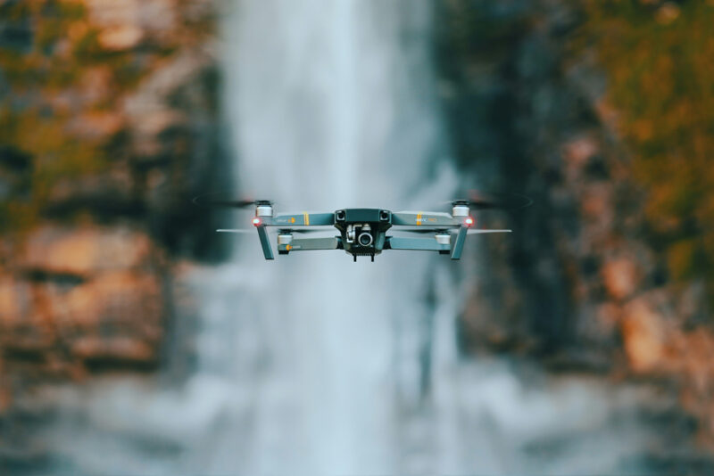Mavic Pro drone hovering in front of waterfall